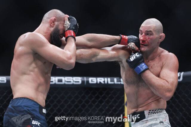 치마예프(왼쪽)가 5월 10일 벌어진 UFC 328에서 스트릭랜드에게 펀치를 허용하고 있다. /게티이미지코리아