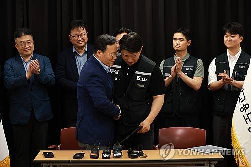 삼성전자 임금협상 잠정 합의(수원=연합뉴스) 홍기원 기자 = 20일 경기도 수원시 장안구 경기고용노동청에서 열린 삼성전자 임금협상을 마친 후 여명구 삼성전자 DS(디바이스솔루션·반도체 사업 담당) 피플팀장과 최승호 삼성그룹 초기업노동조합 삼성전자지부 위원장이 잠정 합의안에 서명한 후 손을 맞잡고 있다. 2026.5.20 [공동취재] xanadu@yna.co.kr