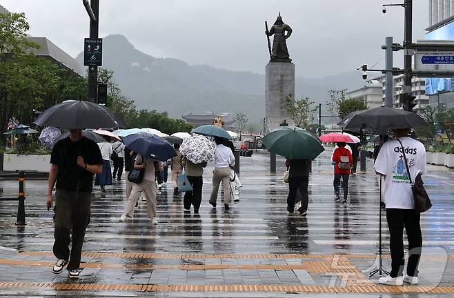 비가 내리고 있는 6일 오전 서울 종로구 세종대로 사거리에서 우산을 쓴 시민들이 이동하고 있다. 2026.7.6 ⓒ 뉴스1 이종수 기자