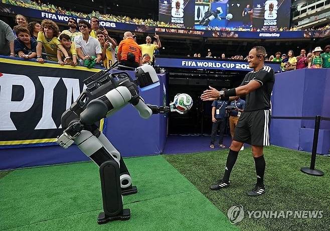 현대자동차그룹의 로봇 전문 계열사 보스턴다이내믹스의 휴머노이드 로봇 '아틀라스'가 FIFA 월드컵 2026 16강전 하프타임에서 손흥민 등 스타 선수들의 세리머니를 재현한 후 심판에게 경기구를 전달하는 퍼포먼스를 선보이는 모습. /사진=연합뉴스