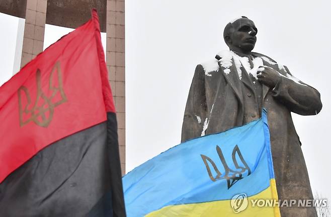 우크라이나 르비우의 스테판 반데라 동상과 UPA 깃발(왼쪽) [EPA=연합뉴스 자료사진. 재판매 및 DB 금지]