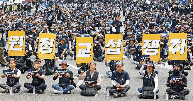 지난달 10일 서울 광화문광장 인근에서 열린 전국금속노조 1만 간부 결의대회에서 참가자들이 ‘원청 교섭 쟁취’ 팻말을 들고 있다./ 연합뉴스