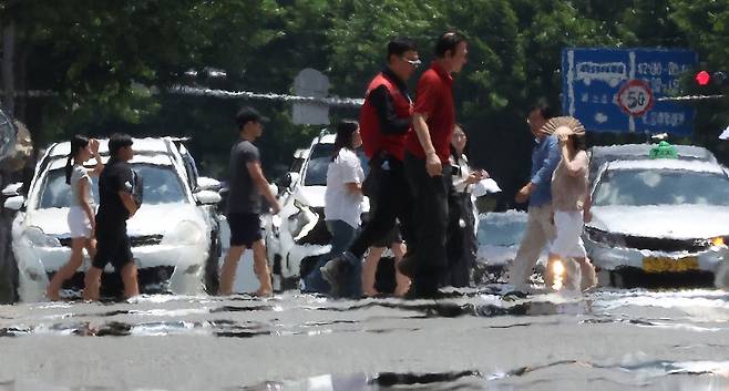 대구에 폭염 경보가 발효된 11일 대구 중구 공평네거리에서 시민들이 지열로 인한 아지랑이가 피어오르는 도로 위를 지나가고 있다. 연합뉴스.