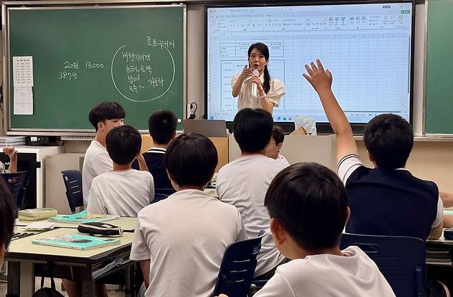 15일 오전 서울 양천구 양정중 1학년 4반에서 김나영 사회 교사가 통화량과 물가에 대해 모의 경매를 통해 학생들에게 설명했다. 모의 경매에서 손을 들고 가격을 외치고 있는 학생 모습. 이보람 기자