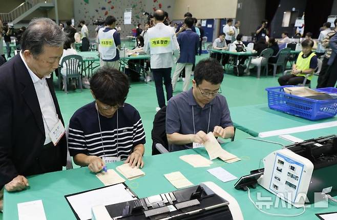 [충주=뉴시스] 이병찬 기자 = 15일 충북 충주 교통대 체육관 충주시장 재검표 개표장에서 선관위 소속 공무원들이 수개표 작업을 진행하고 있다.2026.07.15.bclee@newsis.com