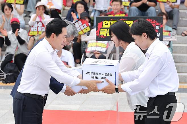 장동혁 국민의힘 대표가 16일 서울 여의도 국회 본청 앞 계단에서 열린 입틀막법 폐지 촉구 및 국민특검 동의 서명 전달식에서 서명서를 전달받고 있다. 2026.7.16 ⓒ 뉴스1 신웅수 기자