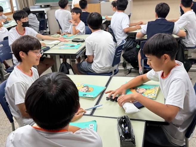 지난 15일 서울 양정중학교 1학년 4반 학생들이 ‘바둑알 경매’에 앞서 화폐로 사용할 바둑알을 세고 있다. 뉴스1