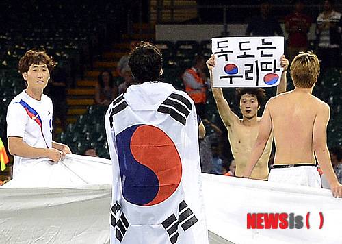 [카디프(영국)=뉴시스[서재훈 기자 = 10일(현지시간) 저녁 영국 카디프 밀레니엄 스타디움에서 런던올림픽 축구 한국 축구 올림픽대표팀과 일본 대표팀과의 3-4위 결정전이 열린 가운데 대한민국이 일본을 2:0으로 완파하고 동메달을 확정, 선수들이 대형 태극기를 들고 박종우(오른쪽 두번째) 선수가 '독도는 우리땅' 손 피켓을 들어보이고 있다. jhseo@newsis.com