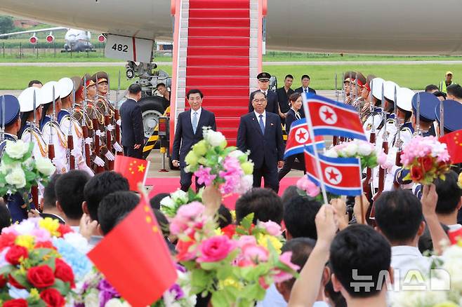 [평양=AP/뉴시스] 왕후닝 중국 공산당 중앙정치국 상무위원이 15일 북한 평양 순안국제공항에 도착해 김형식 북한 최고인민회의 상임위원회 부위원장의 영접을 받고 있다. 중국공산당 서열 4위인 왕후닝이 북중 우호조약 체결 65주년을 맞아 2박3일의 일정으로 북한을 방문했다. 2026.07.16.