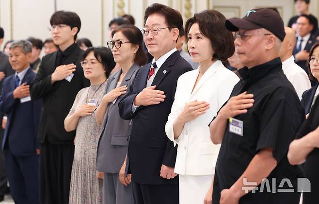 [서울=뉴시스] 조성봉 기자 = 이재명 대통령과 김혜경 여사가 17일 청와대 영빈관에서 열린 '빛의 위원회' 출범 기념 시민 초청 행사에서 참석자들과 국민의례를 하고 있다. 2026.07.17.  suncho21@newsis.com