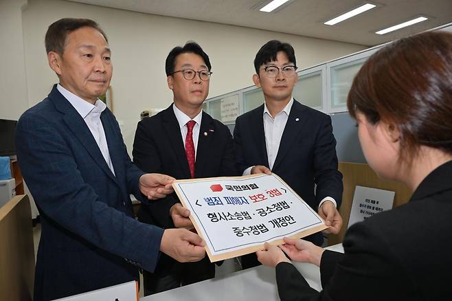 곽규택(가운데) 국민의힘 당 법률자문위원장 등 의원들이 범죄 피해자 보호 3법인 형사소송법·공소청법·중수청법 개정안을 15일 오후 서울 여의도 국회 의안과에 제출하고 있다. 왼쪽부터 국민의힘 김기웅 의원, 곽 위원장, 박충권 의원. 뉴시스