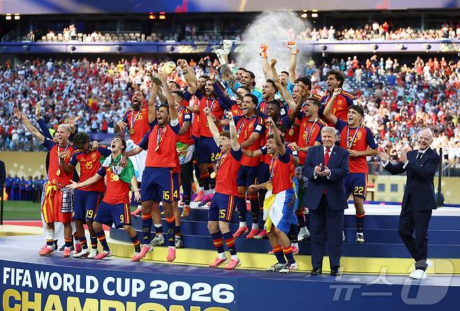 도널드 트럼프 미국 대통령과 잔니 인판티노 국제축구연맹(FIFA·피파) 회장이 지난 2026년 7월 19일 미국 뉴저지주 이스트러더퍼드의 뉴욕 뉴저지 스타디움에서 열린 2026 FIFA 월드컵 결승전 스페인 대 아르헨티나의 경기 종료 후, 월드컵 우승을 차지한 스페인 선수들이 트로피를 들고 자축하는 모습을 바라보고 있다. 2026.7.19. ⓒ 로이터=뉴스1