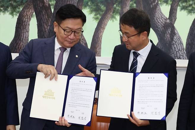 한병도 더불어민주당 대표 직무대행 겸 원내대표와 정점식 국민의힘 원내대표가 21일 국회 운영위원장실에서 선관위 투표용지 부족사태에 따른 특검법안 합의문을 들고 기념촬영을 하고 있다. 공동취재사진