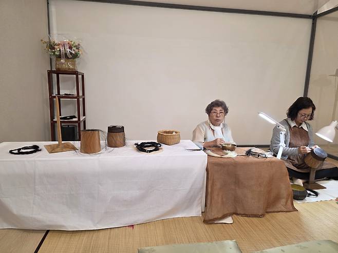Gang Sun-ja, left, master of gannil, the process of making gat (Korea's traditional hat for men), assembles gat. JIN EUN-SOO