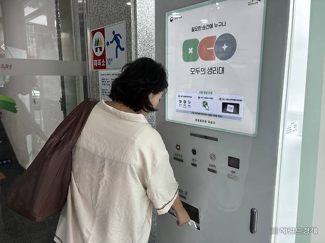 20일 오후 3시께 은평구민 김민정(30) 씨가 서울 은평구청 내 공공생리대 자동지급기에서 생리대 한 팩을 받아 가고 있다. 김서현 수습기자.