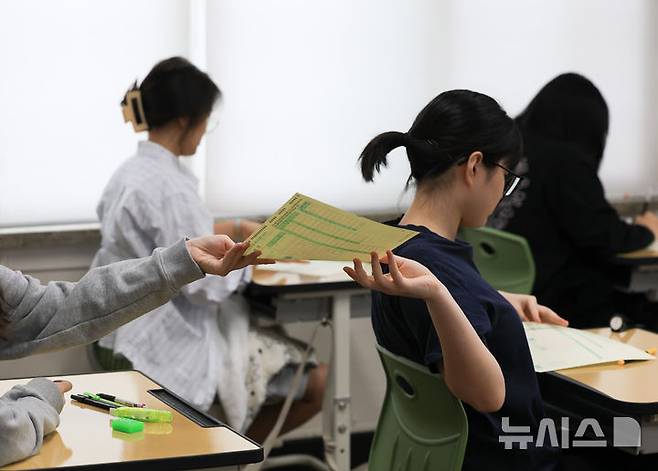 [서울=뉴시스] 사진공동취재단 = 2027학년도 대학수학능력 6월 모의평가일인 6월 4일 오전 서울 마포구 서울여고에서 수험생들이 1교시 국어 영역 시험을 앞두고 OMR 카드를 받고 있다. 2026.06.04. photo@newsis.com