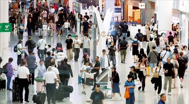 제헌절 연휴를 앞둔 지난 16일 인천국제공항 면세점이 여행객들로 붐비고 있다.  연합뉴스