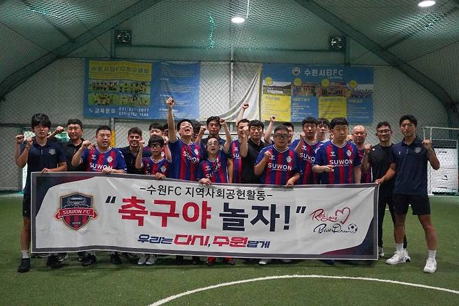 수원FC 선수단이 22일 수원시티FC 풋살장에서 수원시장애인축구협회 소속 성인 회원 30여 명을 대상으로 축구 클리닉을 진행한 뒤 기념촬영을 하고 있다.