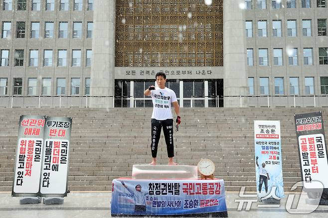 국제환경운동가 '맨발의 사나이' 조승환 씨가 23일 오후 서울 여의도 국회에서 열린 '국민은 고통받고 있다”- 국민을 위한 결단'에서 얼음위에 올라가 정부 규탄 퍼포먼스를 하고 있다. 2026.7.23 ⓒ 뉴스1 황기선 기자