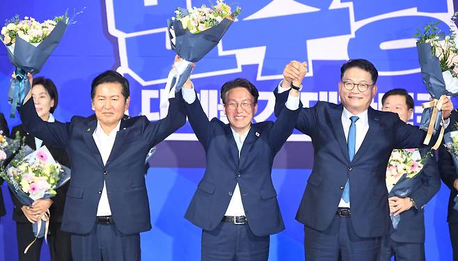 더불어민주당 전당대회 당대표 본경선 진출이 확정된 정청래(왼쪽부터)· 김민석· 송영길 후보가 23일 서울 여의도 국회 의원회관에서 예비경선 결과 발표 뒤 손을 맞잡아 들고 있다. 오승현 기자