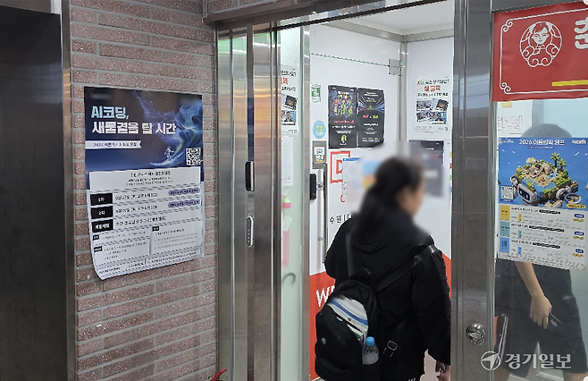 22일 수원특례시 내 한 컴퓨터학원 입구에 AI 관련 특강 안내문이 걸려있다. 사진은 그 옆을 지나는 학생들의 모습. 금유진기자