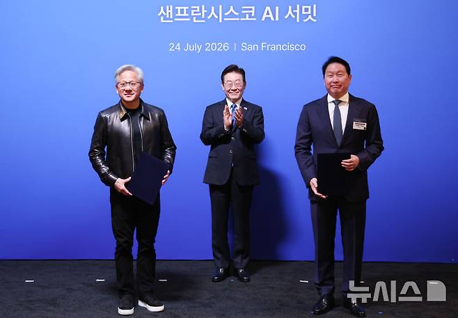 [샌프란시스코=뉴시스] 김진아 기자 = 이재명 대통령이 24일(현지 시간) 미국 샌프란시스코 더 미드웨이에서 열린 샌프란시스코 AI 서밋에서 최태원 SK 회장과 젠슨 황 엔비디아 CEO의 '전략적 AI 팩토리 및 반도체 협력 MOU(업무협약)' 체결을 지켜보고 있다. 2026.07.25. bluesoda@newsis.com