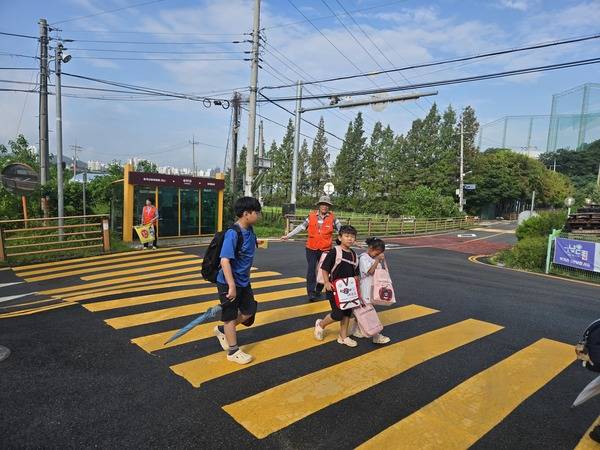 충남 아산 송곡초등학생들의 등하굣길 안전과 학교생활 지원에 앞장서며 든든한 파수꾼 역할을 톡톡히 해내고 있는 어르신 모습. 송곡초 제공.&nbsp;