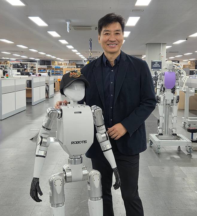 김병수 로보티즈 대표가 연내 판매 예정인 이족보행 휴머노이드 'AI 사피엔스'와 포즈를 취하고 있다./최지희 기자