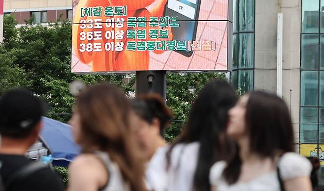 서울 전역에 폭염주의보가 발효된 26일 서울 명동 거리의 한 전광판에 폭염 관련 안내문이 나오고 있다. 연합뉴스