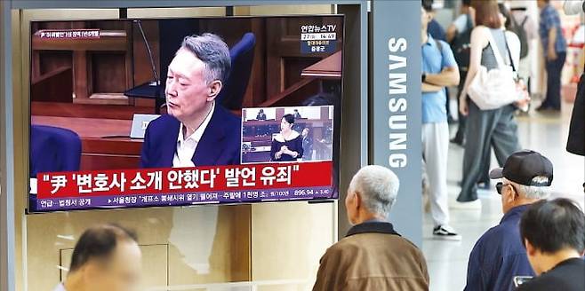 27일 서울역 고객대기실에서 시민들이 윤석열 전 대통령의 공직선거법 위반 혐의 1심 선고 생중계를 보고 있다. 이날 법원은 윤 전 대통령에게 징역 1년6개월에 집행유예 3년을 선고했다. 연합뉴스
