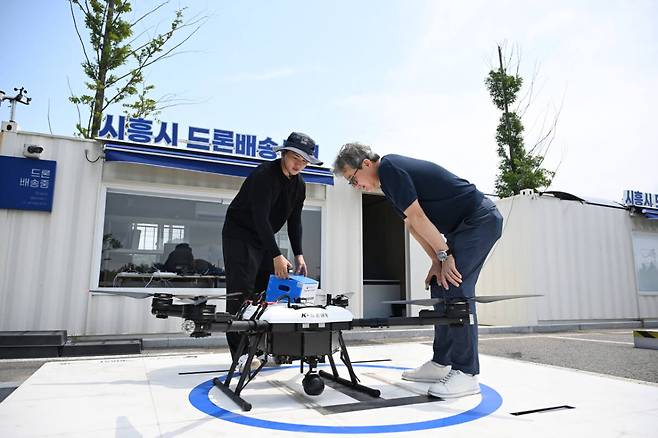 28일 오전 11시, 시흥시 배곧한울공원. 본보 김형수 기자가 주문한 피자를 관제센터 관계자가 드론에 싣고 있다. 김형수 기자