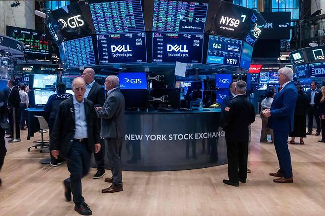 미국 뉴욕증권거래소(NYSE)의 대형 시세 전광판 아래를 관계자들이 오가고 있다. ⒸAFP PHOTO