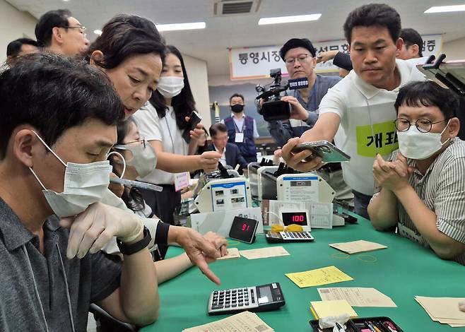 27일 오후 경상남도선거관리위원회에서 열린 6·3 지방선거 경남 통영시장 선거에 대한 재검표가 진행되고 있다. 44표차로 당락이 갈린 통영시장 선거 재검표를 전한길 씨 등이 휴대전화로 기록하고 있다. ⓒ연합뉴스