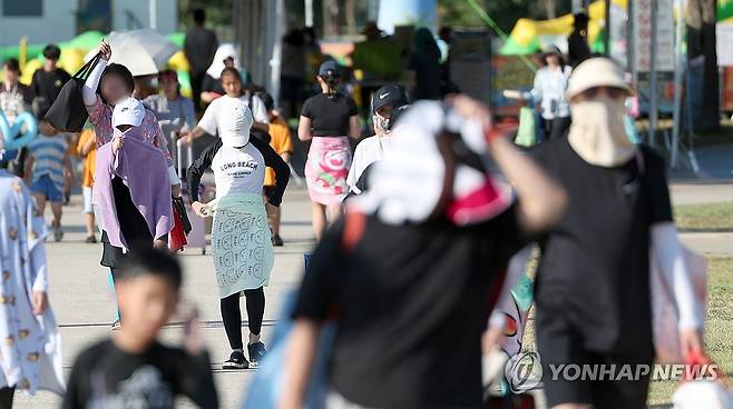 양산 최고기온 40.3도 (양산=연합뉴스) 김동민 기자 = 경남 양산지역 낮 최고기온이 40.3도까지 치솟은 29일 오후 양산시 물금읍 운영이 종료된 황산공원 물놀이장을 나서는 피서객들이 모자와 양산으로 뜨거운 햇빛을 가리고 있다. 2026.7.29 image@yna.co.kr