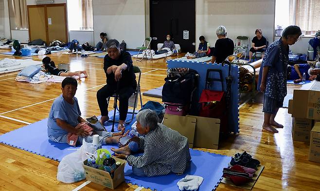 기약 없는 기다림 일본 구마모토현 강진 사흘째인 30일 야쓰시로의 지역 체육관에 마련된 대피소에서 주민들이 휴식하고 있다. 진원과 비교적 가까운 야쓰시로는 제지 공장 굴뚝이 무너져 8명이 사망하는 등 큰 피해가 발생했다. 야쓰시로=로이터연합뉴스