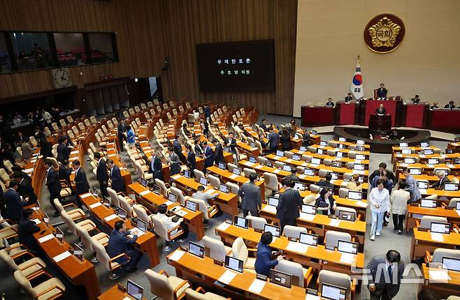 [서울=뉴시스] 고범준 기자 = 주호영 국민의힘 의원이 30일 서울 여의도 국회에서 열린 제437회 국회(임시회) 제3차 본회의에서 형사소송법 개정안에 대한 무제한 토론(필리버스터)을 하고 있는 가운데 더불어민주당 의원들이 이동하고 있다. 2026.07.30. bjko@newsis.com