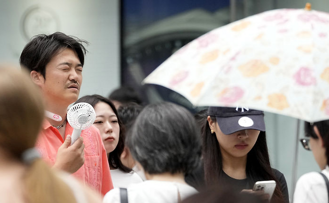 일본 도쿄 긴자에서 한 행인이 휴대용 선풍기를 사용하고 있다. AP 뉴시스