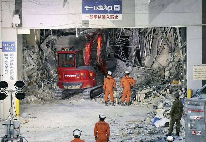 지난달 31일 일본 규슈 구마모토현 가시마에서 소방관들이 중장비를 동원해 지진에 이은 폭발로 파손된 ‘이온몰’ 잔해를 치우고 있다. 2026.07.31. [가시마=AP/뉴시스]