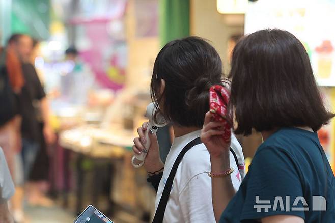 [서울=뉴시스] 권창회 기자 = 4일 서울 강남에서 낮 최고기온 39.2도가 관측되는 등 서울 전역이 펄펄 끓었다. 사진은 지난달 31일 서울 마포구 망원시장에서 고객들이 손풍기를 들고 있는 모습. 2026.07.31. kch0523@newsis.com