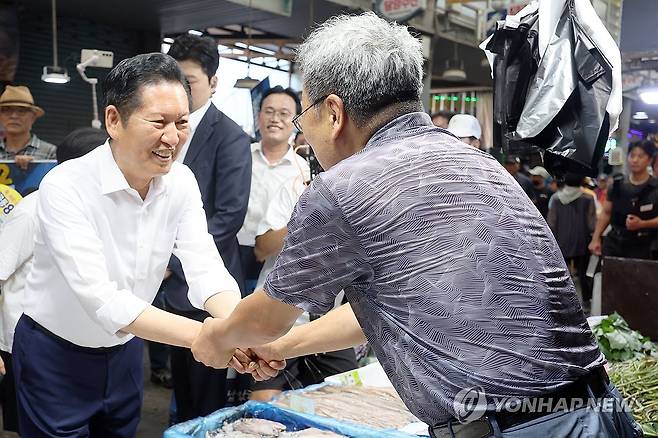 시장 상인과 악수하는 정청래 후보 (전남광주=연합뉴스) 민현기 기자 = 더불어민주당 정청래 당 대표 후보가 4일 오전 전남광주 북구 말바우시장에서 시장 상인과 인사를 나누고 있다. 2026.8.4 mhk0226@yna.co.kr