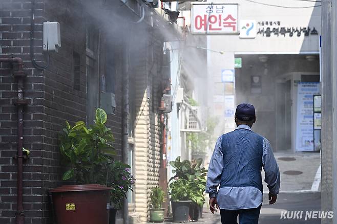 서울 낮 최고 기온이 37도까지 오른 3일 서울 용산구 동자동 쪽방촌에서 한 주민이 쿨링포그를 맞으며 더위를 식히고 있다. 남동균 기자
