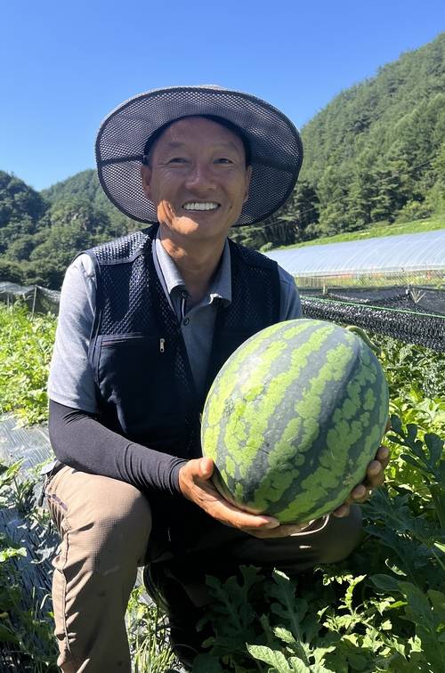 봉화군 법전면 소천1리 박상철 이장이 자신이 재배한 수박을 들어 보이며 환하게 웃고 있다. <황준오기자>