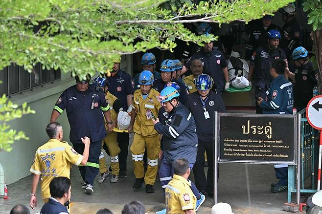 지난 7일(현지시간) 태국 수도 방콕 북쪽 논타부리주 방크루아이 지역의 학교 총기 난사 사건 희생자들의 시신이 학교 밖으로 운구되고 있다. [AFP]