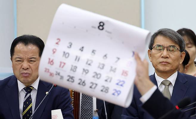 노태악 전 중앙선거관리위원장과 위철환 중앙선거관리위원장 직무대행이 10일 국회에서 열린 ‘제9회 전국동시지방선거 투표용지 부족 사태 등 국민 참정권 침해 진상규명 및 선거관리 개혁을 위한 국정조사 특별위원회’ 제3차 청문회에서 더불어민주당 전용기 의원이 8월 달력을 들어 보이며 재검표 현장검증 날짜의 조속한 확정을 촉구하는 발언을 듣고 있다. [연합뉴스]