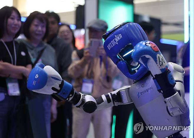 지난해 코엑스에서 열린 스마트라이프위크에 소개된 권투하는 로봇 (서울=연합뉴스) 신준희 기자 = 30일 강남구 코엑스에서 열린 '스마트라이프위크 2025'에서 관람객들이 격투하는 로봇을 구경하고 있다. 2025.9.30 hama@yna.co.kr