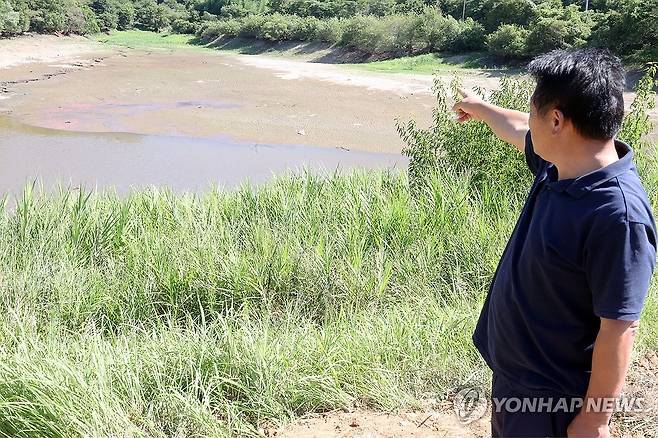 메마른 저수지에 속타는 농심 (곡성=연합뉴스) 민현기 기자 = 가뭄이 이어지고 있는 12일 오전 전남광주 곡성군 석곡면 방송리 방송저수지에서 인근 마을 이장 오규섭(65)씨가 저수지를 가리키고 있다. 2026.8.12 mhk0226@yna.co.kr