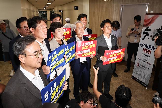 전진숙(가운데) 더불어민주당 의원을 비롯한 전남광주지역구 의원들이 13일 오후 서울 여의도 국회도서관에서 이진숙 국민의힘 의원실 주최로 열린 5.18 민주화운동의 재조명 국회공개포럼장 앞에서 손 피켓을 들고 구호를 외치고 있다. 2026.08.13. 뉴시스 제공.