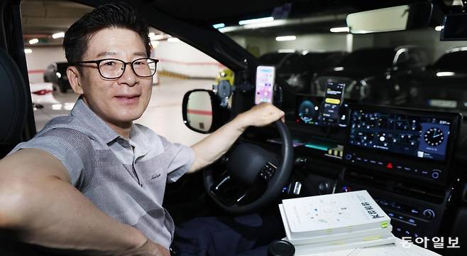 송재철 씨가 서울 종로구 동아미디어센터 지하 주차장에서 자신의 대형 승합 택시 운전대를 잡은 채 미소 짓고 있다. 국민연금공단과 국민건강보험공단에서 33년간 일한 송 씨는 2022년 정년퇴직한 뒤 생애 설계 강사 겸 택시 기사로 일하고 있다. 신원건 기자 laputa@donga.com
