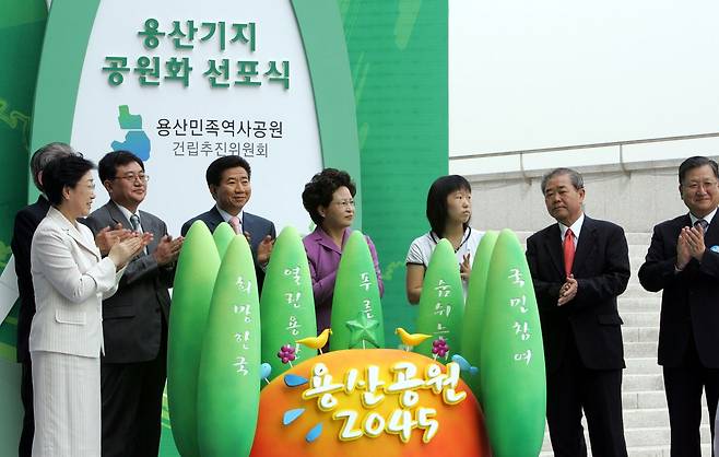 2006년 8월 24일 노무현 대통령(왼쪽에서 네 번째)과 부인 권양숙 여사(왼쪽에서 다섯 번째)가 서울 용산국립박물관에서 개최된 '용산기지 공원화 선포식'에 참석해 어린이들로부터 건네받은 희망의 나무를 퍼포먼스 상징물에 꽂은 후 박수를 치고있다. 중앙포토