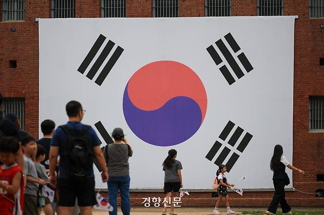 16일 광복절을 기념해 ‘2026 서대문독립민주축제’가 열리고 있는 서울 서대문독립공원을 찾은 시민들이 대형 태극기 앞에서 기념사진을 찍고 있다. 이준헌 기자